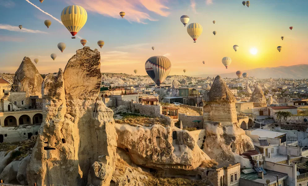 Cappadocia hot air balloons flying above valleys at sunrise